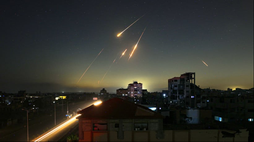 Foto tirada de Nuseirat, no centro da Faixa de Gaza, mostra rastros de foguetes no céu no final de 13 de junho de 2025, depois que o Irã atacou Israel com barragens de mísseis após um ataque massivo contra as instalações nucleares e militares da república islâmica